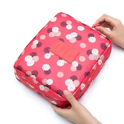 Floral-patterned pink storage bag with a hand holding it on a white background