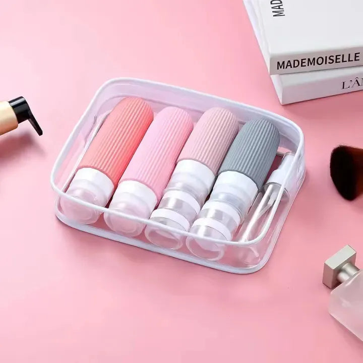 Set of small cylindrical containers with caps in a clear plastic case on a pink background